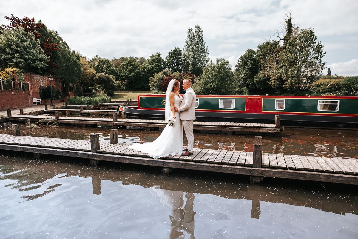 The Bride and Groom pose for photographs on one of the jetty's at Ali and Mat's wedding which was hosted at Lion Quays Resort in Shropshire.